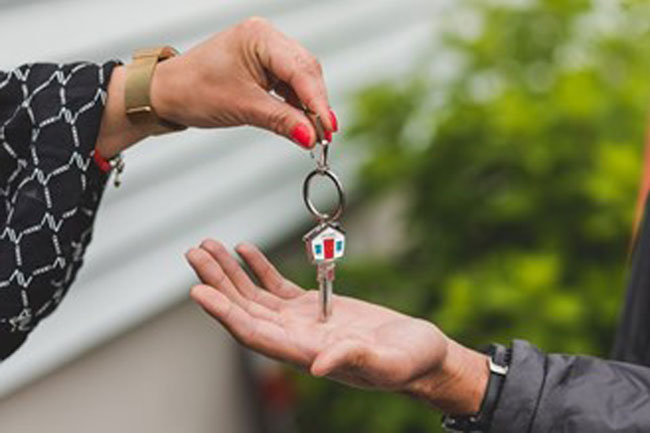 A woman receiving a key to her new home before moving in
