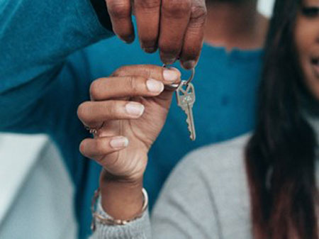 Two people holding a spare key
